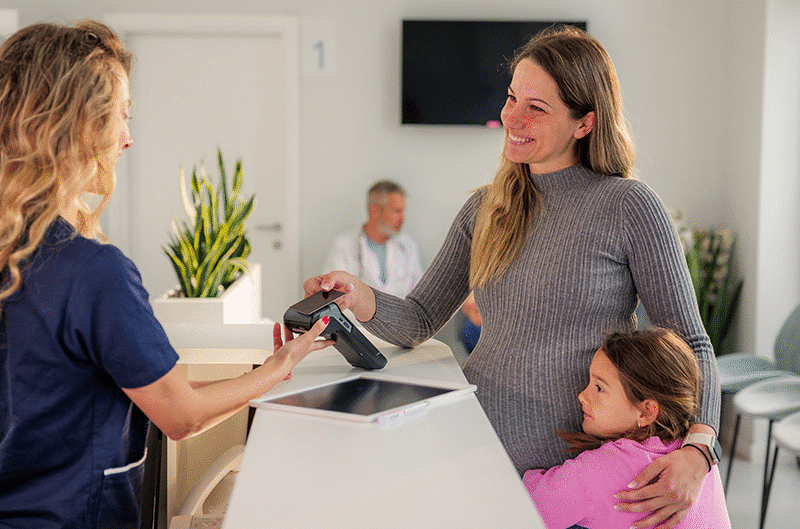 woman making payment in goverment clinic, need for updated government payments system blog - intellipay