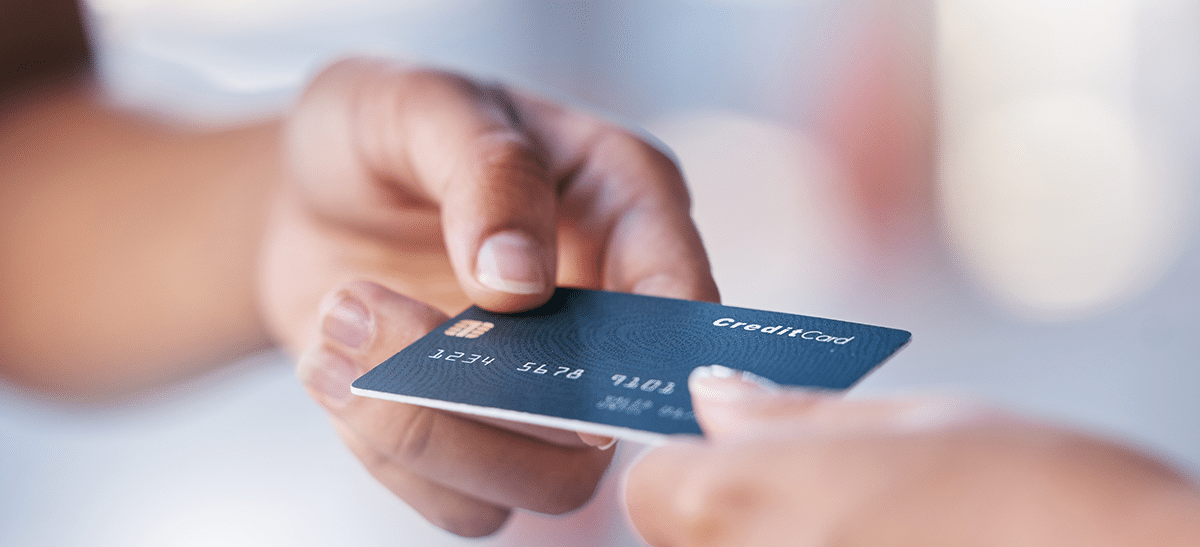 Handing a credit card to make a payment - Small business growth article IntelliPay
