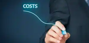 A business professional drawing a downward arrow under the glowing word "COSTS," symbolizing credit card fee reduction and interchange optimization for small businesses