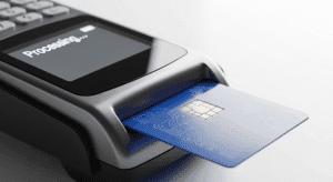 Customer inserting a credit card into a Dejavoo payment terminal at a checkout counter, illustrating a smooth, uninterrupted payment transaction during a processor switch.