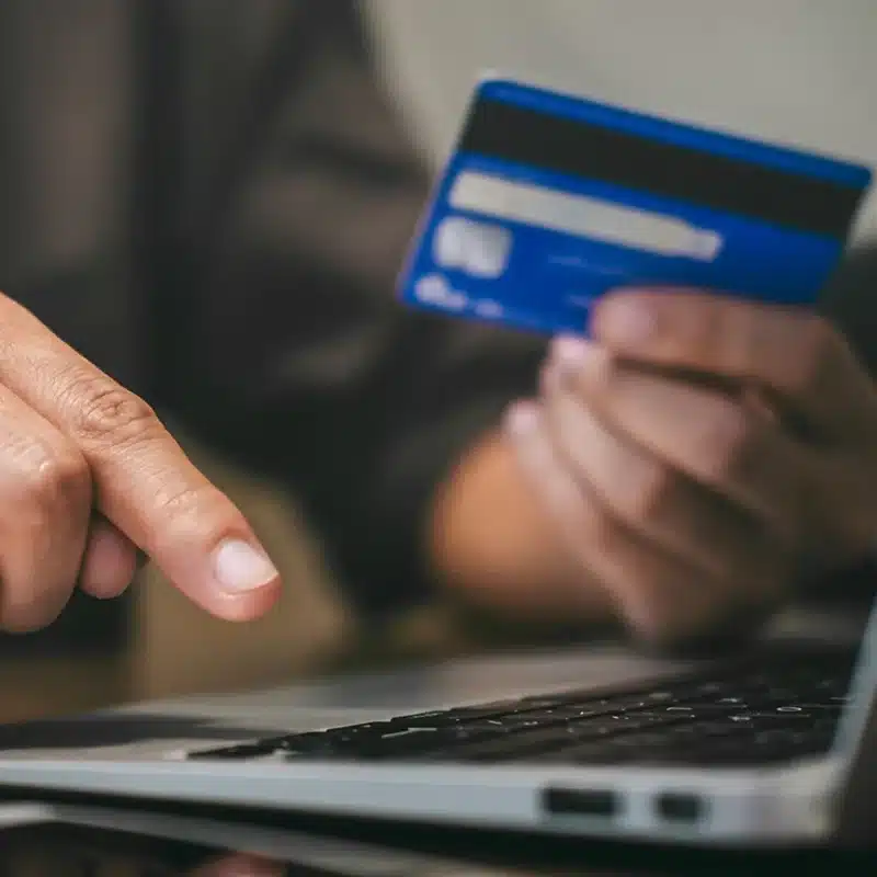 A business owner reviewing a merchant statement to identify hidden debit fraud fees and the 0.05 percent invisible tax charged by issuing banks