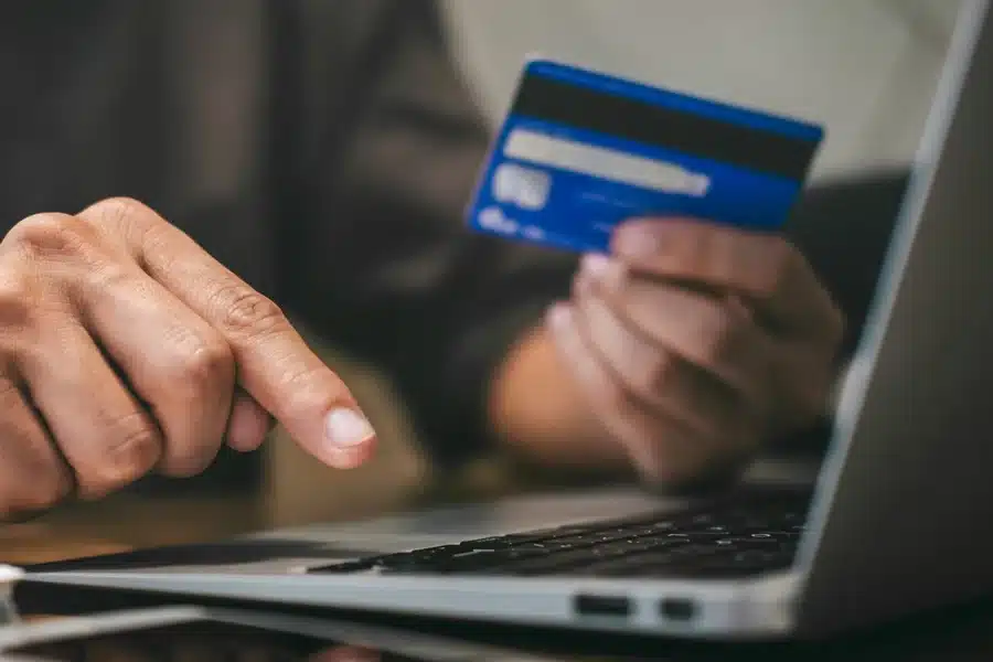 A business owner reviewing a merchant statement to identify hidden debit fraud fees and the 0.05 percent invisible tax charged by issuing banks