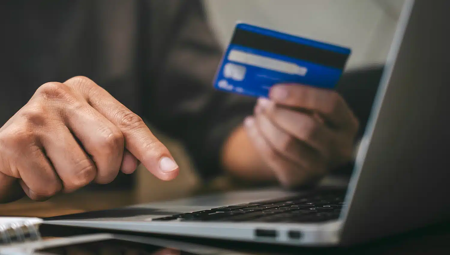 A business owner reviewing a merchant statement to identify hidden debit fraud fees and the 0.05 percent invisible tax charged by issuing banks
