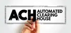 Hand writing "ACH AUTOMATED CLEARING HOUSE" on a glass board