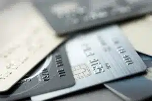 Alt Text: A close-up, artistic stack of various credit and debit cards, highlighting the different chips and embossed textures of premium rewards and corporate cards