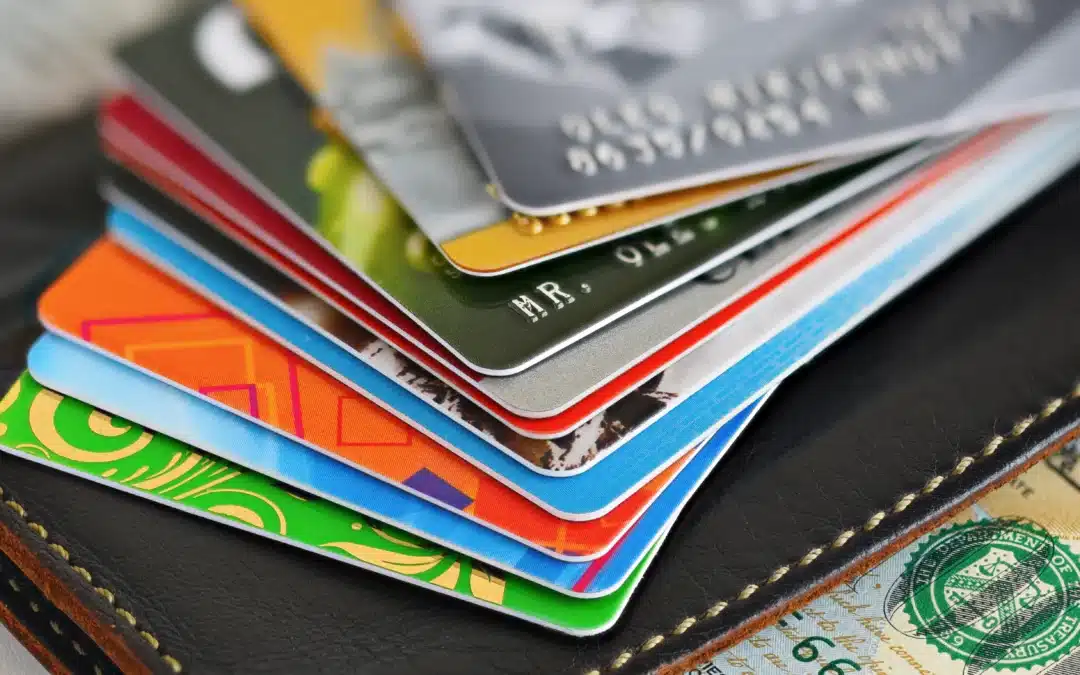 Close-up of a stack of multiple credit cards on a wallet, illustrating various consumer payment choices and fee structures