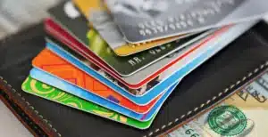 Close-up of a stack of multiple credit cards on a wallet, illustrating various consumer payment choices and fee structures