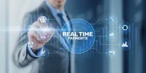 Businessman pointing to a glowing "Real Time Payments" interface with digital network icons representing FedNow and RTP instant payment systems
