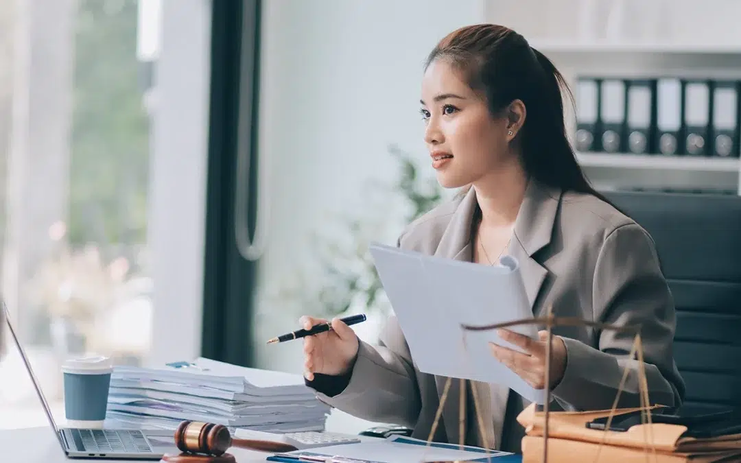 emale attorney at desk reviewing documents with laptop and gavel representing payment processing for law firms and professional services firms