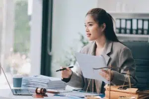Professional services attorney payment processing intellipay emale attorney at desk reviewing documents with laptop and gavel representing payment processing for law firms and professional services firms
